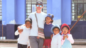 a picture of a volunteer with kids in the andes