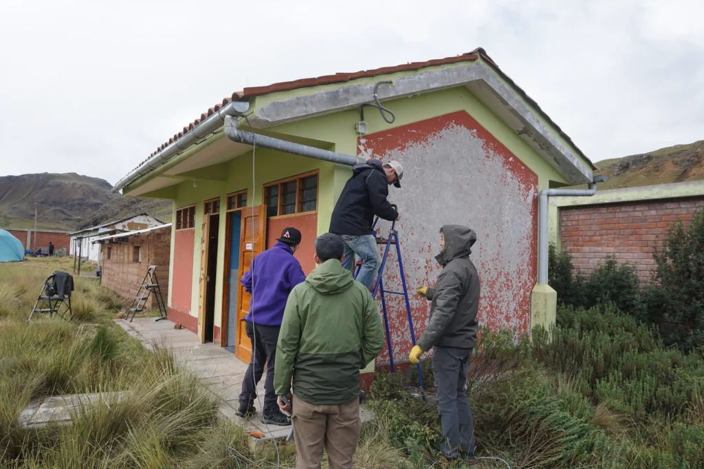 Volunteers installing solar panels at a primary school in Ccollpapata, Peru through LUTW’s csr charity donations project