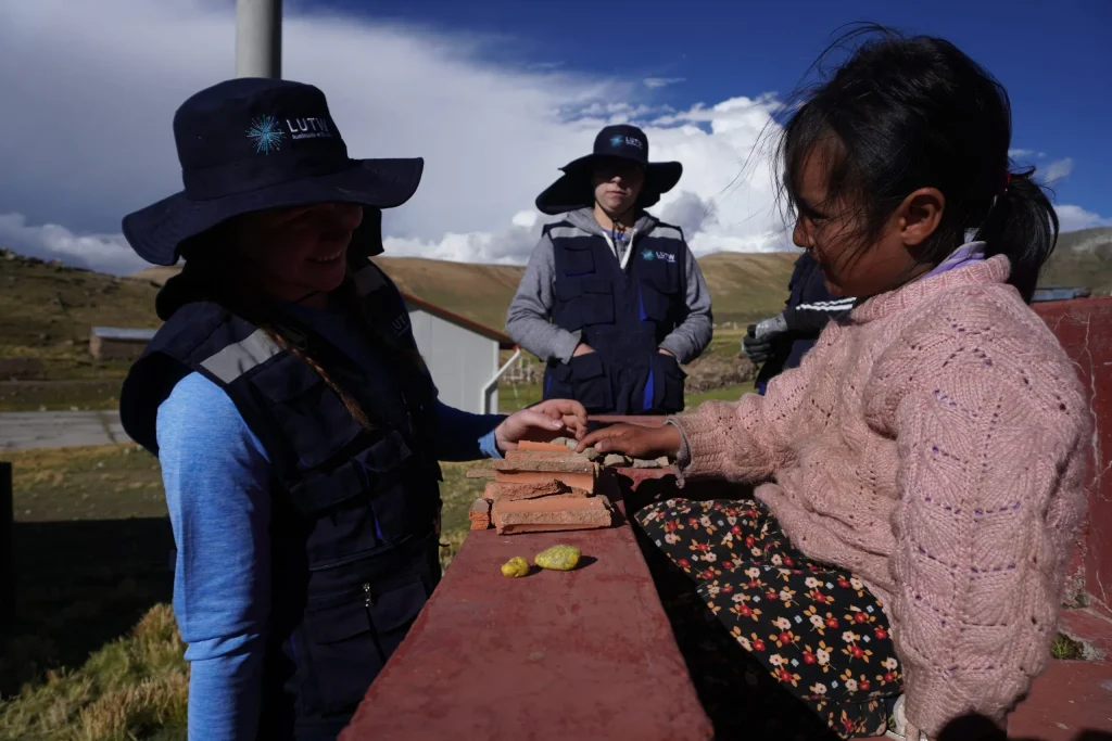 Young Peruvian child and Western University volunteers at Pauchintani school powered by solar energy
