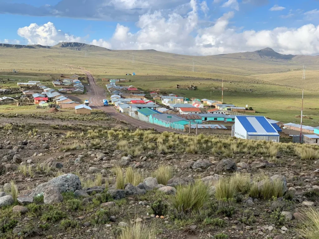 Wide landscape view of the remote rural community of Pedregal nestled in the hills, featuring the local houses and school buildings supported by the LUTW solar energy charity project.