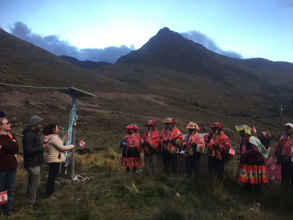 Volunteers and locals standing by newly installed solar panel in Peru
