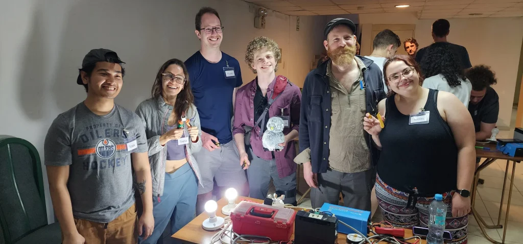 Group of smiling student volunteers holding solar lights and equipment during LUTW’s not for profit solar project in Huarcaya, Peru