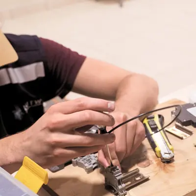 Hands of a volunteer installing solar equipment as part of a solar energy charity project supported by charitable giving CSR