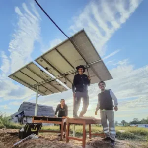 Student volunteers standing under a solar panel installation during LUTW’s solar for non profits project in rural Peru